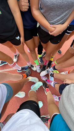 a group of people standing in a circle with their feet together