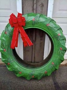 a green wreath with a red bow hanging on the front door to show it's holiday spirit