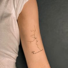 a woman's arm with a small tattoo on the left side of her arm