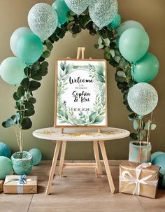 a welcome sign with balloons and greenery