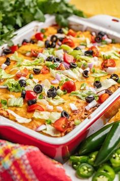 a red casserole dish filled with lots of toppings and garnish