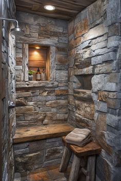 a bathroom with stone walls and a wooden bench