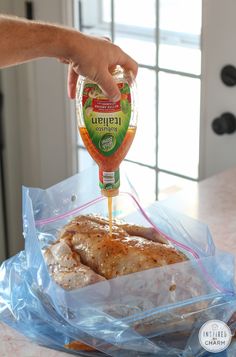 someone is pouring ketchup on some food in a plastic bag with another chicken