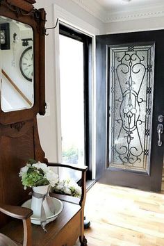 a vase with flowers sitting on a table in front of a mirror next to a door