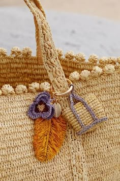 a close up of a bag with a flower on the handle and a keychain attached to it