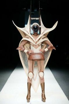 a woman is walking down the runway wearing an unusual outfit