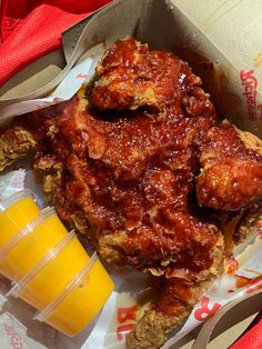 a close up of a plate of food with chicken wings and orange juice on the side