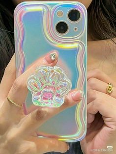 a woman holding up a phone case with an image of a flower on it in front of her face