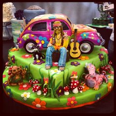 a colorful cake with a person sitting on top of it