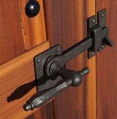 an iron handle on a wooden door