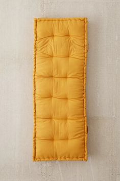 an orange sleeping bag hanging on the wall next to a white wall with no one in it