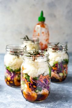 four jars filled with food sitting on top of a table