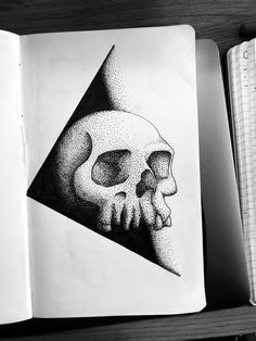 an open book with a drawing of a skull on it's cover and a triangle in the middle