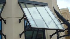 an awning on the side of a building with black iron bars and glass windows