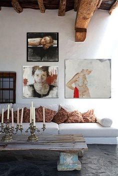 a living room filled with furniture and pictures on the wall above it's coffee table