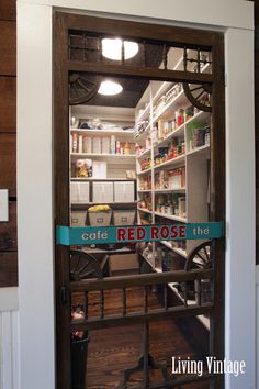 an open door to a store filled with lots of food and drinks on shelves next to a wooden floor