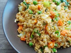 a plate filled with rice and vegetables on top of a wooden table