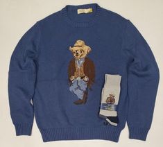 DENIM & SUPPLY RALPH LAUREN COWBOY POLO BEAR GRAPHIC SWEATER WITH MATCHING SOCKS NAVY HEATHER COWBOY POLO BEAR GRAPHIC SWEATER RIBBED CREW-NECK PULLOVER STYLE EMBROIDERED POLO BEAR AT FRONT INTENTIONAL FRAYING ON GRAPHIC ADDED FOR AN AUTHENTIC LOOK 100% COTTON HAND WASH ONLY IMPORTED Ralph Lauren Cowboy, Cowboy Sweater, Polo Bear Ralph Lauren, Fun Fits, Thrift Wishlist, Sweater Socks, Matching Socks, Men's Outfits, Bear Men