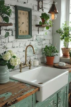 a kitchen sink sitting under a clock next to potted plants on a counter top