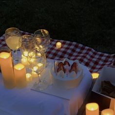 a table topped with candles and plates filled with food