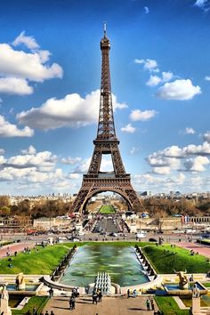 the living room is decorated with white furniture and wallpapers, along with a view of the eiffel tower