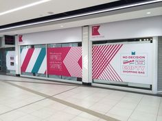 an empty shopping mall with posters on the walls and flooring in front of them