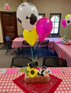 a table topped with cake and balloons in the shape of cow's head on top of a piece of bread