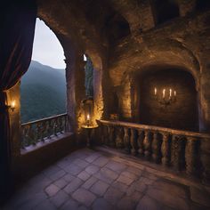 an outdoor area with stone walls and pillars, lit by candles on either side of the balcony