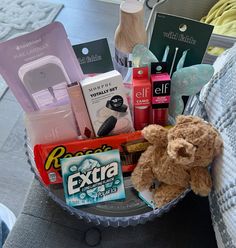 a teddy bear sitting in a basket filled with personal care items