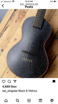 a black and walnut ukulele is on the floor