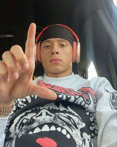 a young man wearing headphones making the vulcan sign