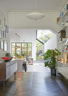 a living room filled with lots of furniture and decor on top of hard wood flooring