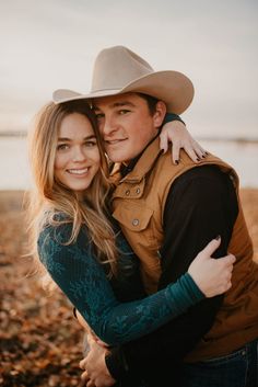 a man and woman hugging each other on the beach