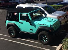 a blue and white jeep parked in a parking lot