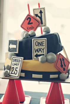 a birthday cake decorated with street signs and traffic cones