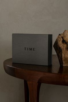 a box sitting on top of a wooden table next to a piece of driftwood