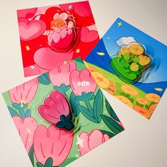 three cards with flowers on them sitting next to each other and one has a paper cut out of it