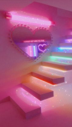 a heart shaped neon sign on the side of a wall next to stairs with lights