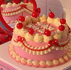 a heart shaped cake sitting on top of a counter next to a mirror with cherries