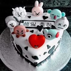 a heart shaped cake decorated with cartoon characters