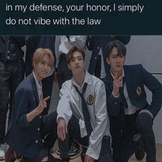 three young men sitting next to each other in front of a group of police officers