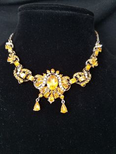 "This necklace not only has beautiful Yellow Emerald cut stones but also tiny White peals which are handset into open bezel caps and than prong set. It is marked \"Hollycraft\" on the back, but also has a dated, \"Copr. 1953.\" According to Maryanne Dolan author of Collecting Rhinestone & Colored Jewelry,\" dated jewelry is rare\". The necklace is crowed with various sizes and shapes of colored Yellow Rhinestones and Seed Pearls. Some even go as far to say that Hollycraft Jewelry is Hollywoo Vintage Metal Choker With Jewels, Vintage Jeweled Jewelry For Evening, Retro Jeweled Wedding Jewelry, Retro Jeweled Gold Jewelry, Retro Gold Jeweled Jewelry, Collectible Costume Jewelry With Jewels, Retro Metal Jewelry, Vintage Jewel Necklaces Collectible, Vintage Jeweled Jewelry For Parties