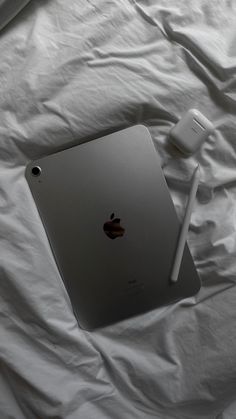 an apple ipad is sitting on a white sheet