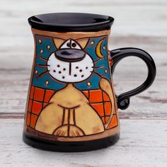 a ceramic mug with a dog painted on it