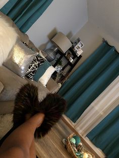 a person's feet with furry slippers on the floor in front of a couch