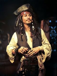 a man dressed as captain jack sparrow with his hands in his pockets and wearing a pirate's hat