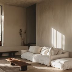 a living room filled with furniture next to a large window covered in sun shining through the windows