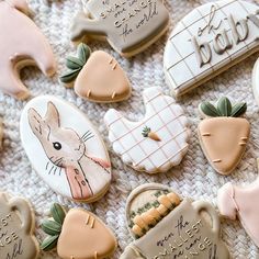 decorated cookies with writing on them sitting on top of a white tablecloth covered in frosting