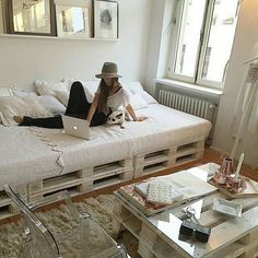 a woman laying on top of a bed in a living room