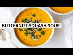 two bowls of butternut squash soup with spoons